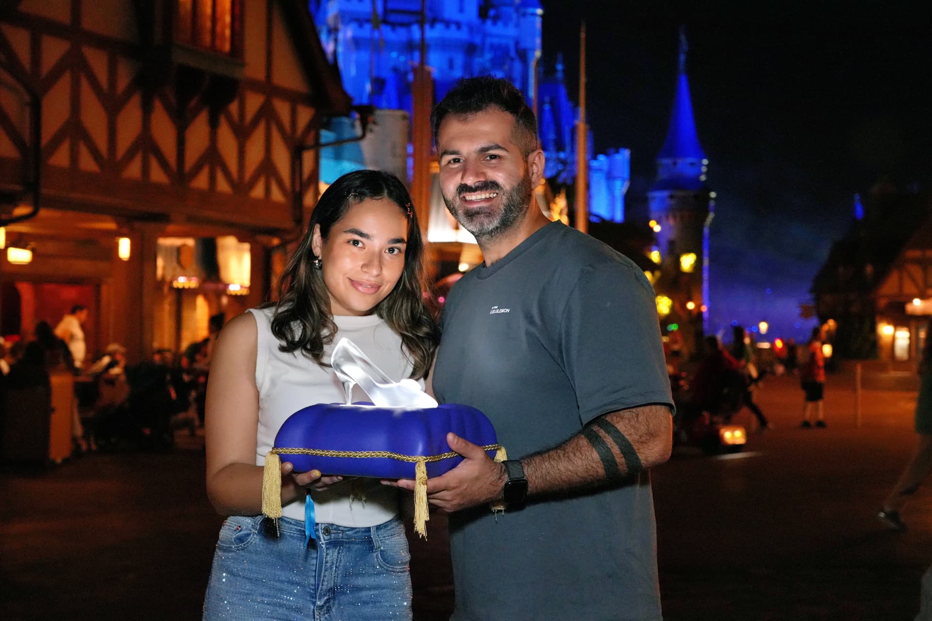 Couple with glass slipper in front of Cinderella Castle