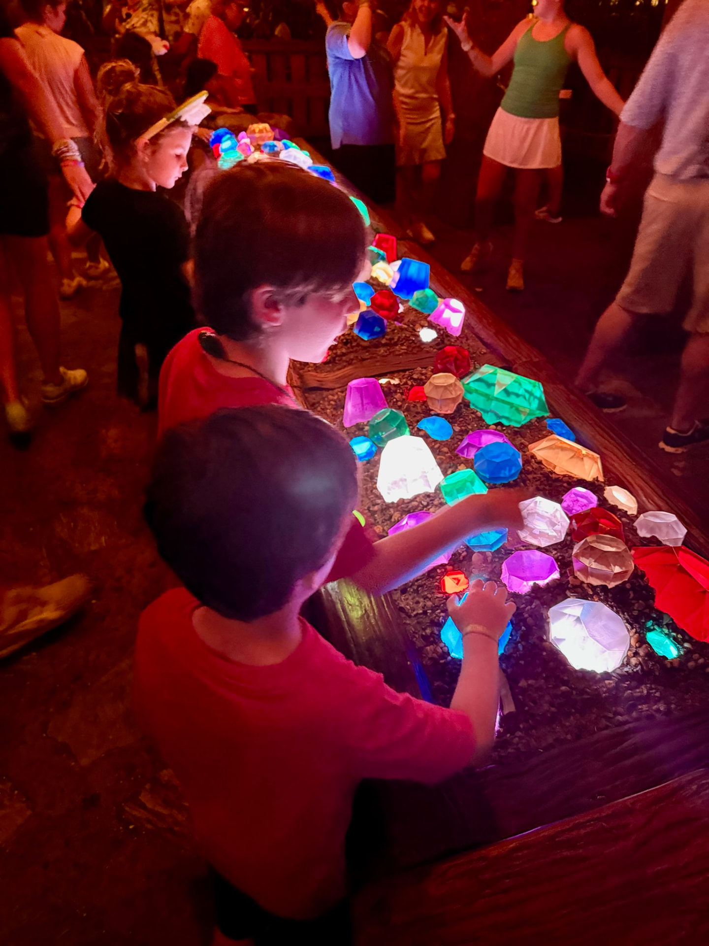 Kids playing with glowing gems on the Na'vi River Journey queue